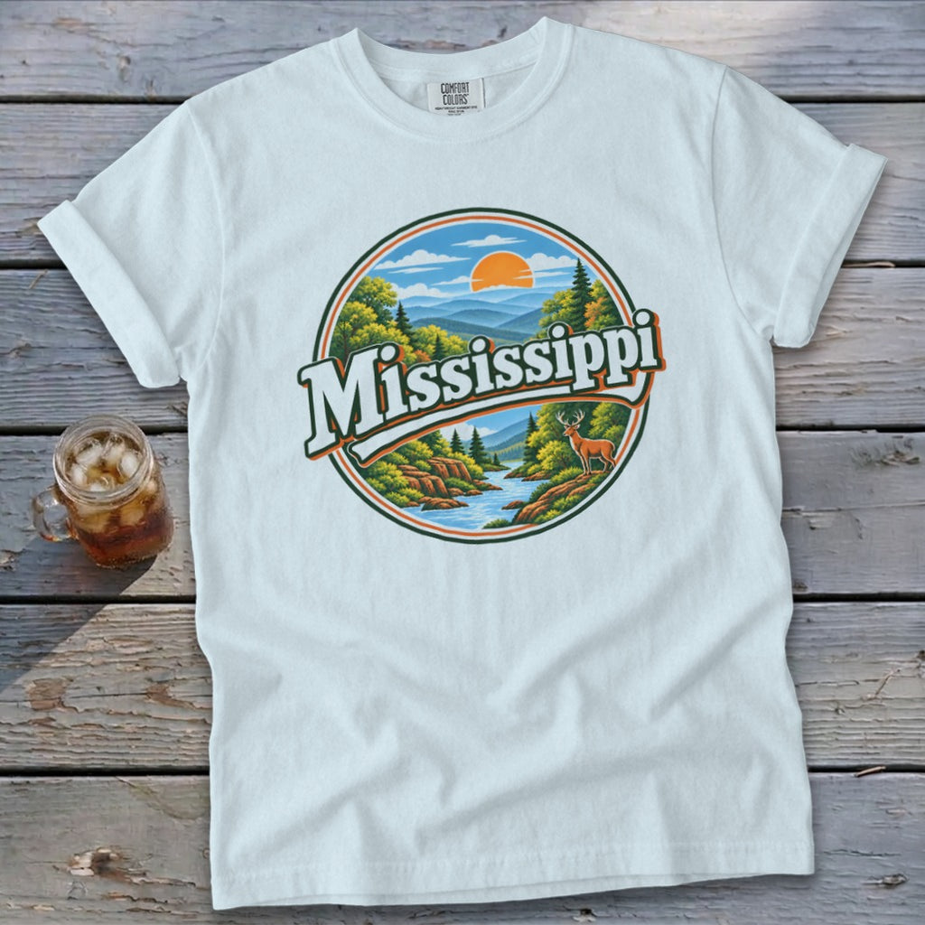 White t-shirt with circular graphic depicting a scenic river, forest, and deer with "Mississippi" text.