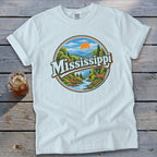 White t-shirt with circular graphic depicting a scenic river, forest, and deer with "Mississippi" text.