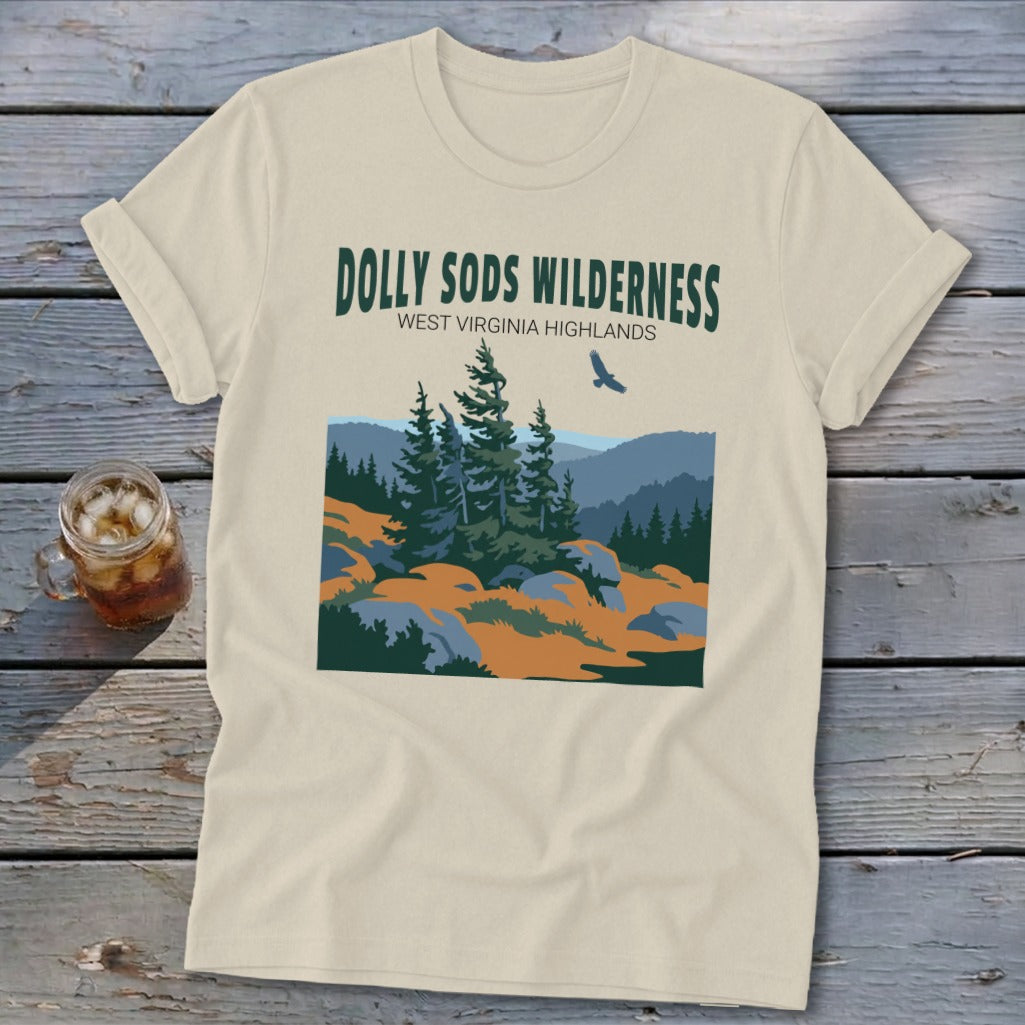 A cream-colored t-shirt featuring a stylized graphic of the Dolly Sods Wilderness with evergreen trees and mountains.
