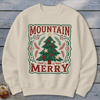 Beige crewneck sweatshirt featuring a graphic of a decorated Christmas tree with the text MOUNTAIN MERRY.