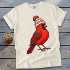 A white t-shirt featuring an illustration of a red cardinal wearing a winter beanie with a pom-pom.