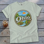 Light green t-shirt with circular Ohio nature scene graphic featuring deer and river.