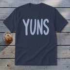 Navy t-shirt with light blue "YUNS" text and a mug of iced tea.