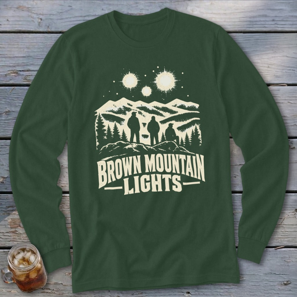 Dark green long-sleeve shirt featuring a graphic of three figures, mountains, stars, and the text Brown Mountain Lights.