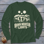 Dark green long-sleeve shirt featuring a graphic of three figures, mountains, stars, and the text Brown Mountain Lights.