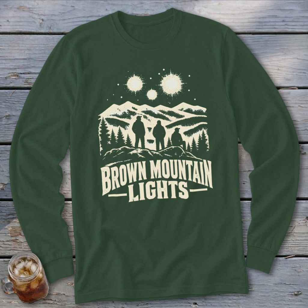 Dark green long-sleeve shirt featuring a graphic of three figures, mountains, stars, and the text Brown Mountain Lights.