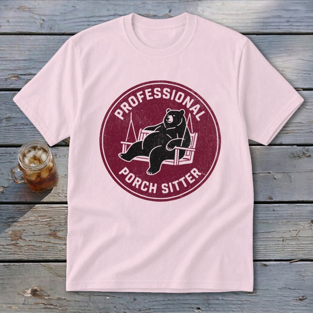 Light pink t-shirt featuring a maroon circular graphic with a lounging bear and text reading Professional Porch Sitter.