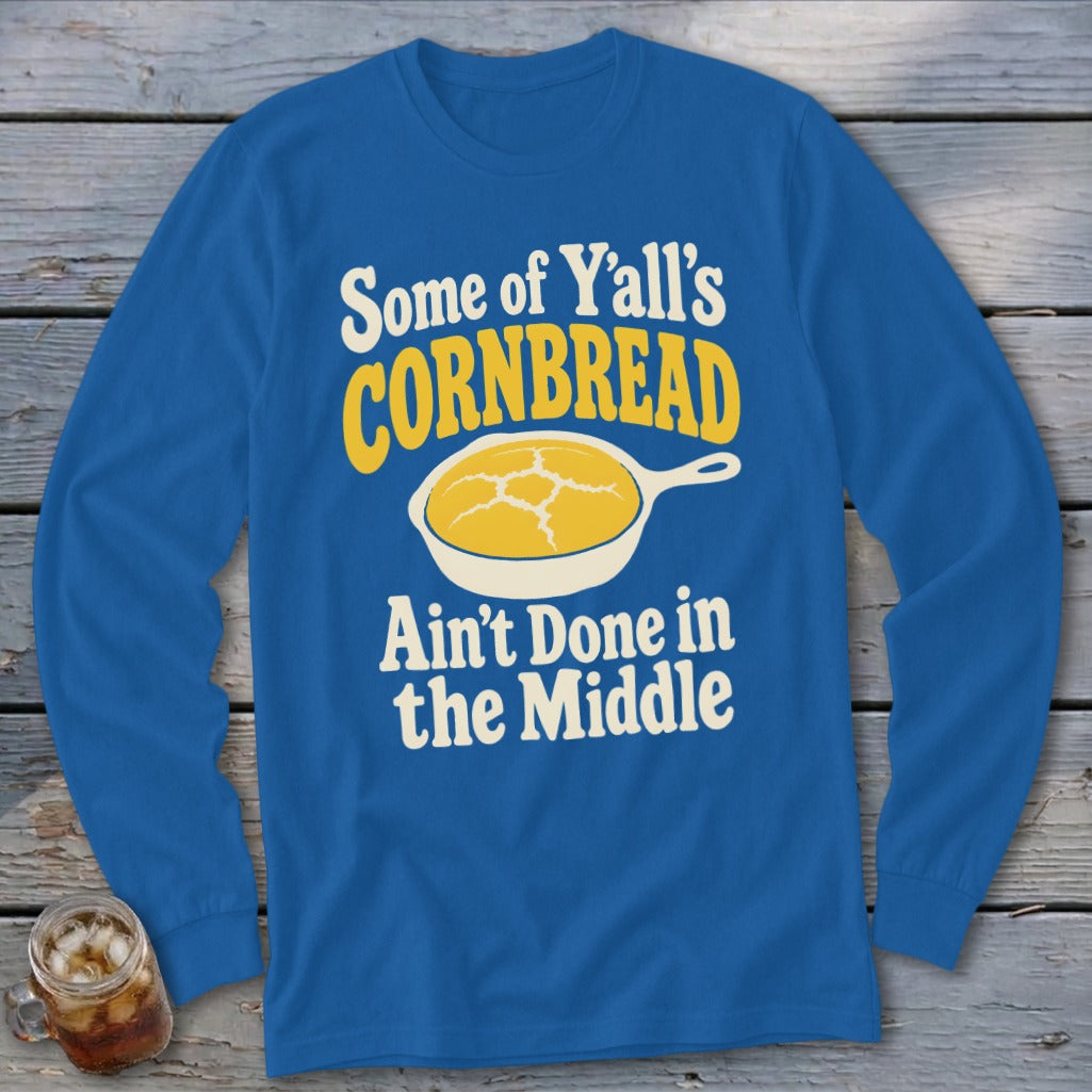 Royal blue long-sleeve t-shirt with a graphic of cornbread in a skillet and text reading Some of Y’all’s Cornbread Ain’t Done in the Middle.