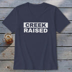 Navy v-neck t-shirt with white text reading "CREEK RAISED".