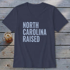 Navy v-neck t-shirt with "North Carolina Raised" text in light blue.