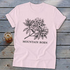 Pink t-shirt with a black ink sketch of flowering branches and "MOUNTAIN BORN" text.