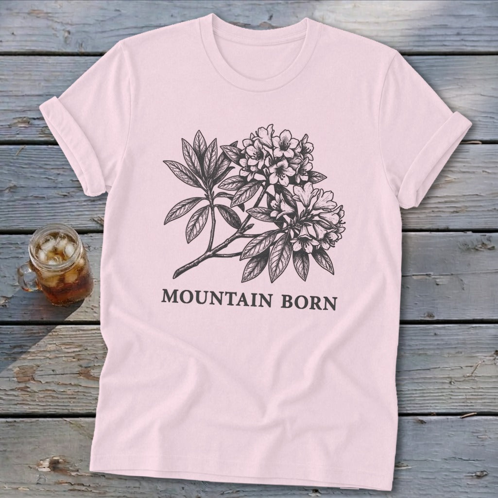 Pink t-shirt with a black ink sketch of flowering branches and "MOUNTAIN BORN" text.
