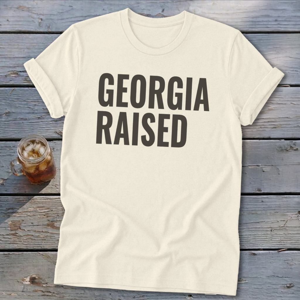 Cream t-shirt with "GEORGIA RAISED" in dark grey block letters.