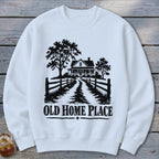 White sweatshirt with black graphic of a house, trees, fence, and text "OLD HOME PLACE".