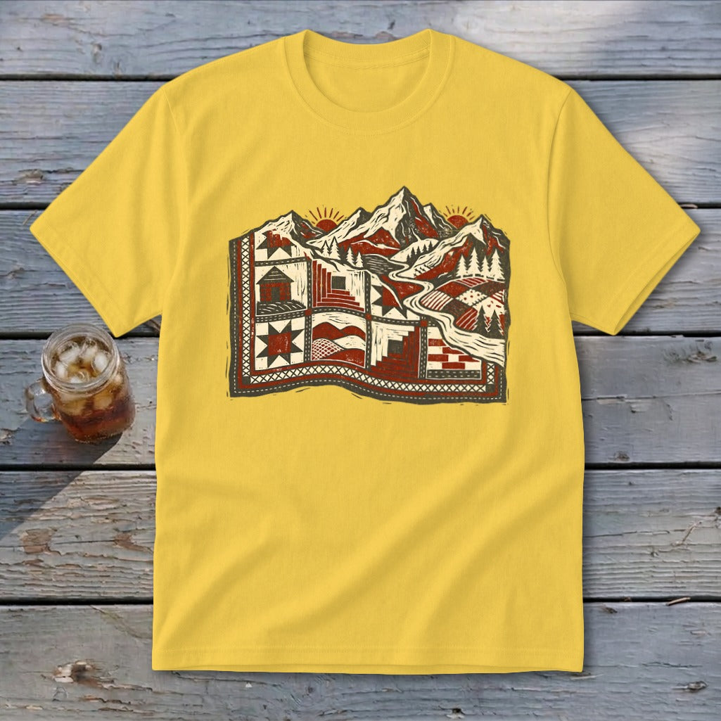 A yellow t-shirt with a graphic of a mountain landscape designed as a quilt.
