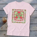 Pink t-shirt with a decorative square design featuring red flowers, green foliage, and "Mountain Blood" text.