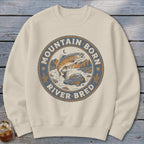 Cream sweatshirt with a circular graphic of a leaping trout, rocks, trees, and the text "Mountain Born River Bred".