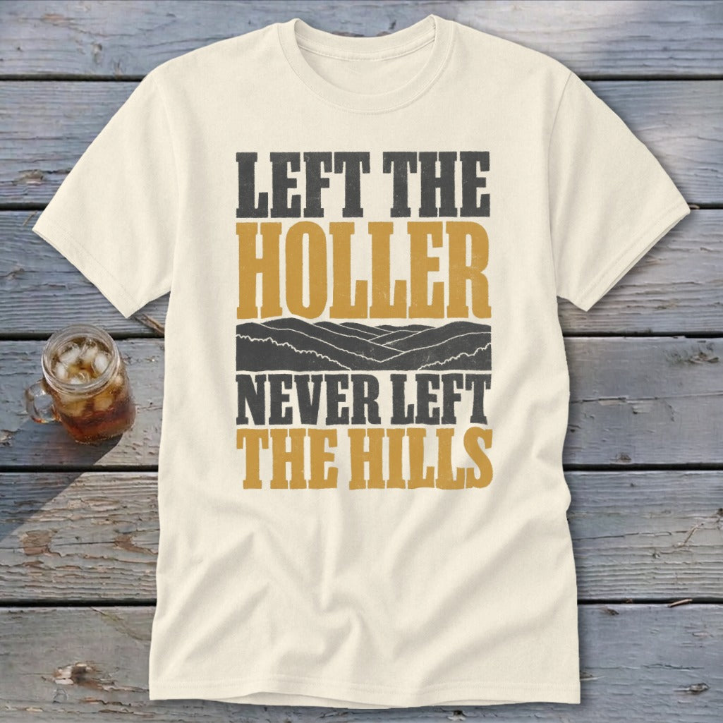 Cream t-shirt with text "LEFT THE HOLLER NEVER LEFT THE HILLS" and mountain graphic.