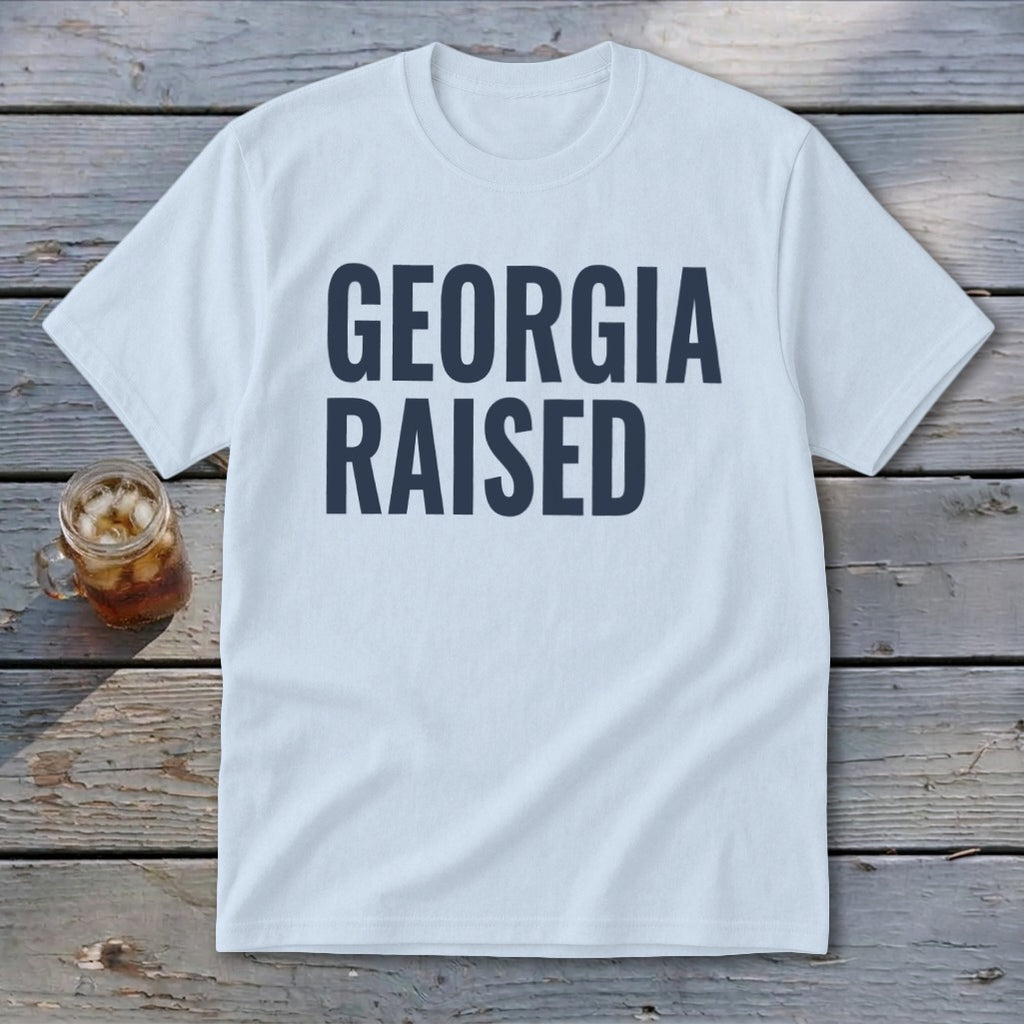 White t-shirt with navy blue text reading "GEORGIA RAISED"