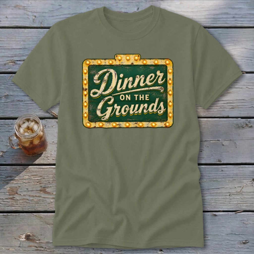 Olive green short-sleeve t-shirt featuring a vintage marquee sign graphic that reads Dinner on the Grounds.