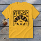 Yellow t-shirt featuring a black block-print graphic of a woolly worm, snowflakes, and the text Woolly Worm Winter Prophet.
