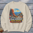 Sweatshirt with fall mountain scene and text "Peak weekend. Same playlist. New overlook."