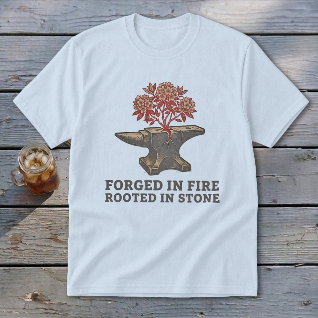 White t-shirt with anvil graphic, flowering plant, and text "FORGED IN FIRE ROOTED IN STONE".