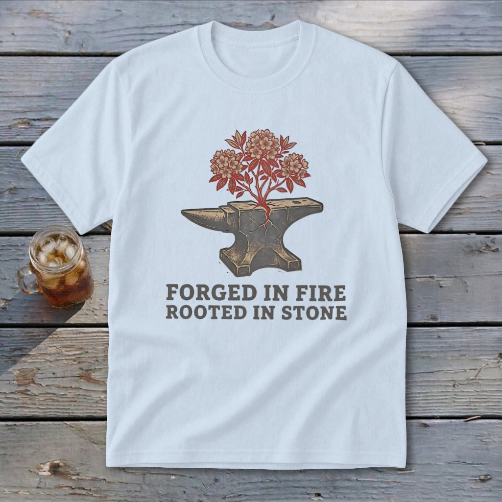 White t-shirt with anvil graphic, flowering plant, and text "FORGED IN FIRE ROOTED IN STONE".