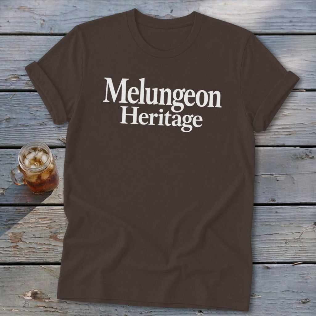 Dark brown t-shirt featuring the white serif text Melungeon Heritage on a rustic wooden background.