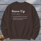 A brown crewneck sweatshirt featuring white text defining the term Stove Up on a rustic wooden background.