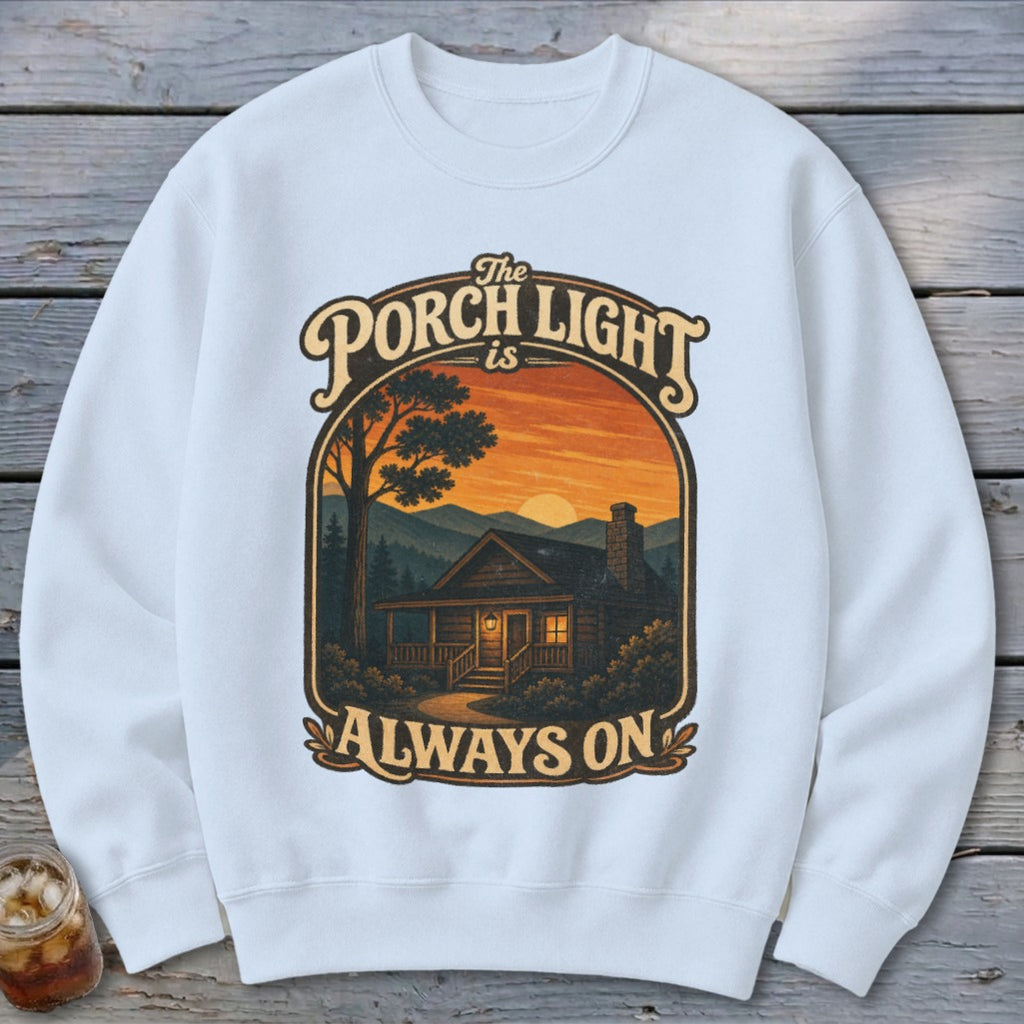 White sweatshirt with "The Porch Light is Always On" text and cabin scene.