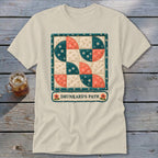 Cream t-shirt with a "Drunkard's Path" quilt design and floral accents.