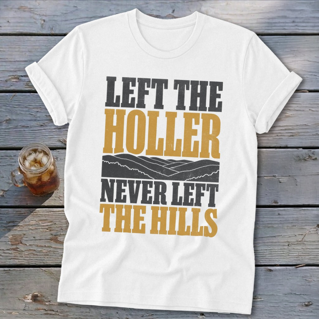 White t-shirt with "Left the Holler Never Left the Hills" text and mountain graphic.