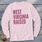 Pink long sleeve shirt with "West Virginia Raised" printed in purple text.