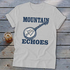 Light gray t-shirt featuring blue text that reads "MOUNTAIN ECHOES" surrounding a vintage banjo illustration.