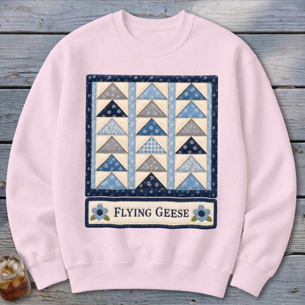 Pink sweatshirt with a blue and gray flying geese quilt design and "Flying Geese" text.