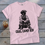 Pink t-shirt with black graphic of boy holding bucket and text "COAL CAMP KID".
