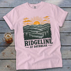 Pink t-shirt with "RIDGELINE AT DAYBREAK" text and a mountain landscape graphic.
