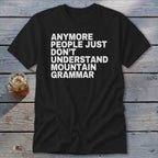 Black t-shirt with white text reading "anymore people just don't understand mountain grammar".
