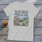 White t-shirt with "Blue Ridge Bloom" text and mountain landscape with flowers.