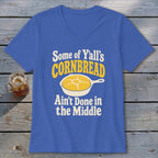 Blue V-neck t-shirt featuring the text "Some of Y'all's Cornbread Ain't Done in the Middle" and a yellow cornbread graphic in a skillet.