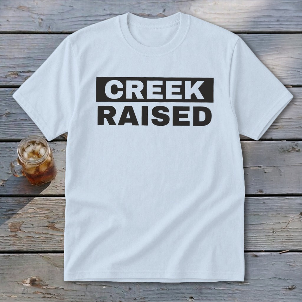 Light blue t-shirt with black text reading "CREEK RAISED"
