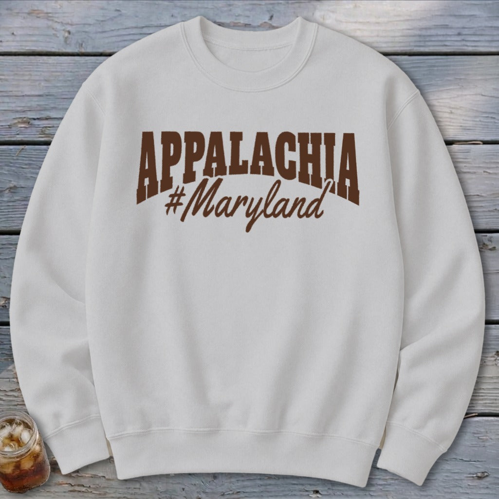 White sweatshirt with brown "APPALACHIA #Maryland" graphic text.