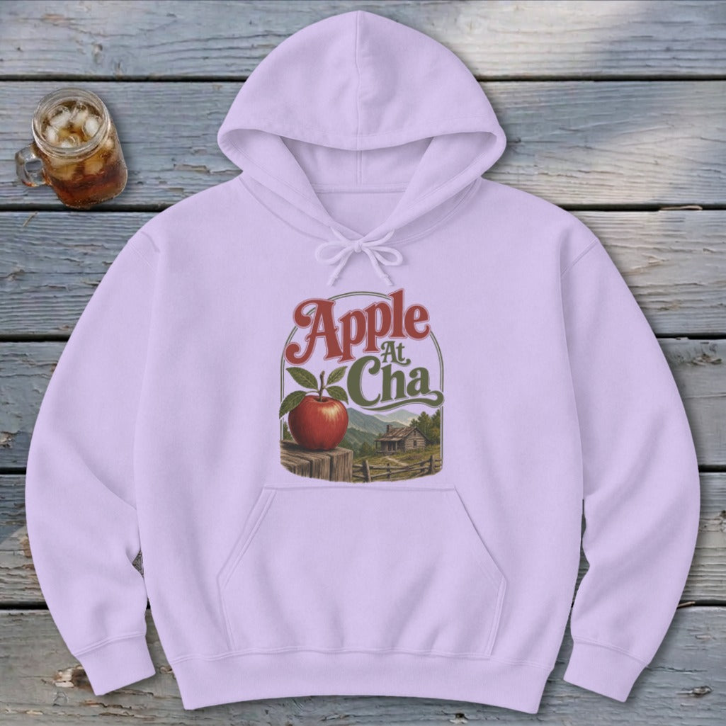 A light purple hoodie featuring a graphic with an apple, a cabin, and text reading Apple At Cha.