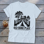 White t-shirt with a graphic of a farmhouse, trees, and the text "OLD HOME PLACE."