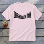 Pink t-shirt with black text reading "GUESS WHERE I'M FROM"