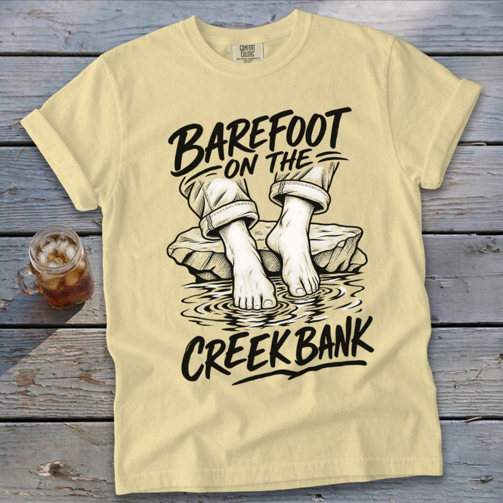 Light yellow t-shirt with "Barefoot On The Creek Bank" text and graphic.