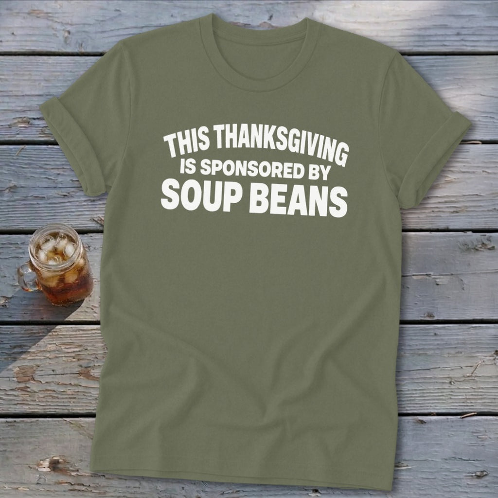 An olive green crewneck t-shirt with white text reading THIS THANKSGIVING IS SPONSORED BY SOUP BEANS.