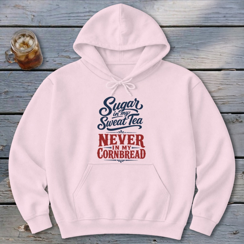 Light pink hooded sweatshirt with a pocket and text reading Sugar in my Sweet Tea, Never in my Cornbread.
