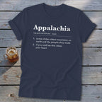 Dark blue t-shirt featuring white text that defines Appalachia, displayed on a weathered wooden surface.
